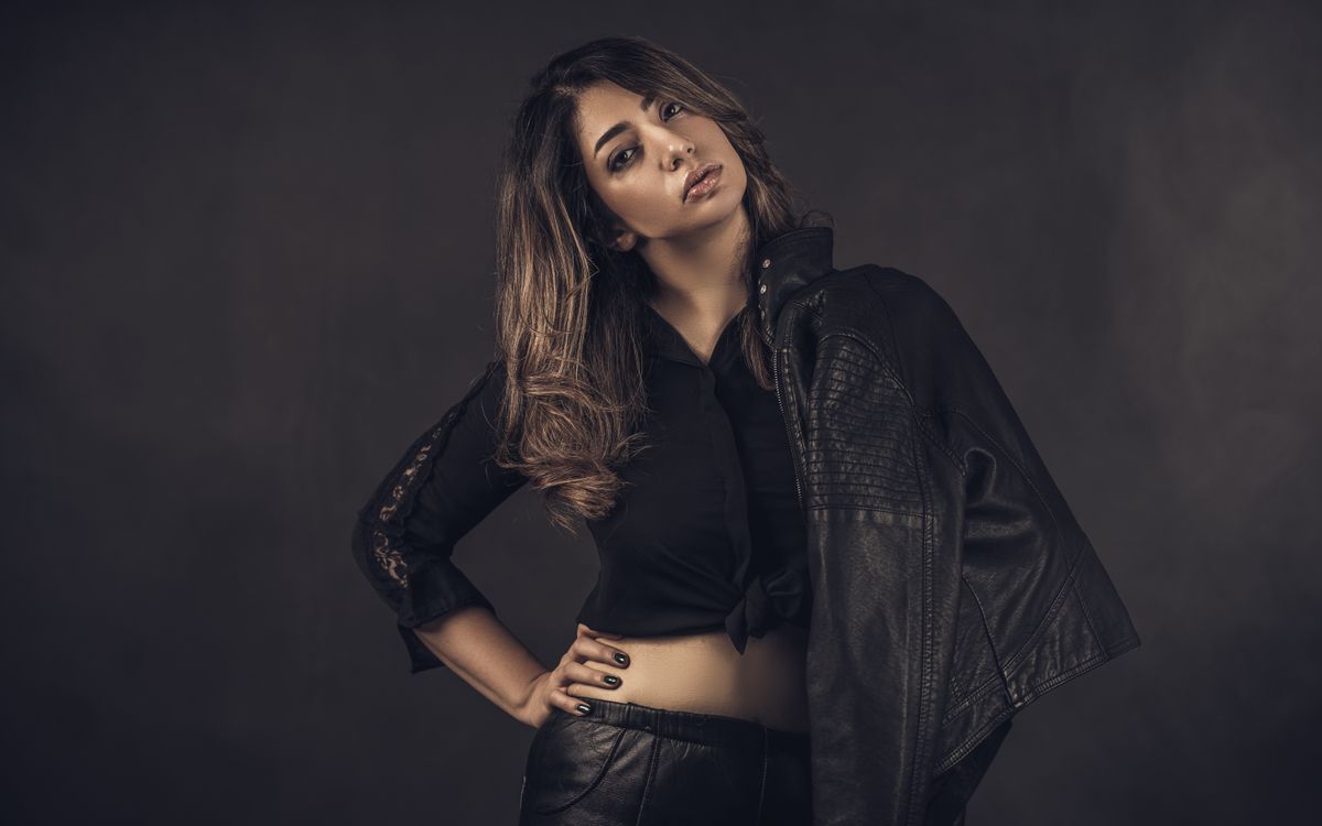Mujer elegante con una chaqueta de cuero negro suave, retrato de estudio de ambiente sobrio
