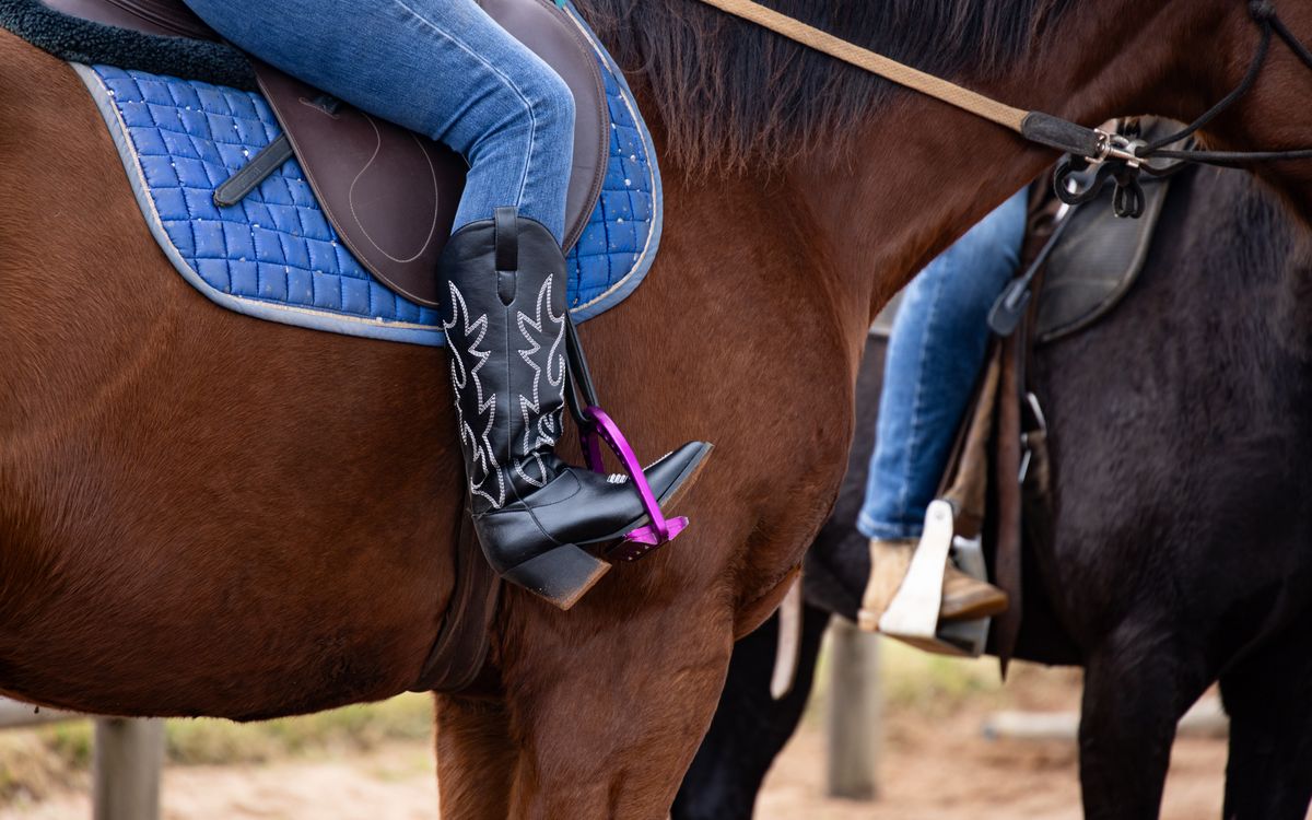 Una silla de montar y unas botas western de cuero, envejecidas