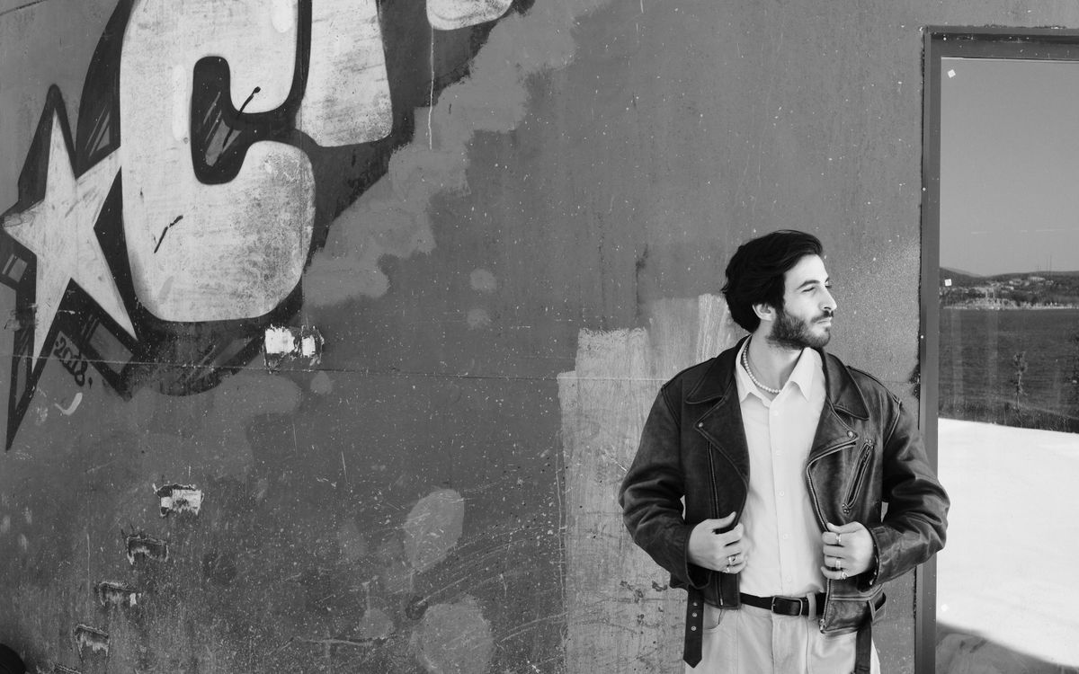 Una figura con chaqueta de cuero sobre un fondo urbano, ruda y protectora