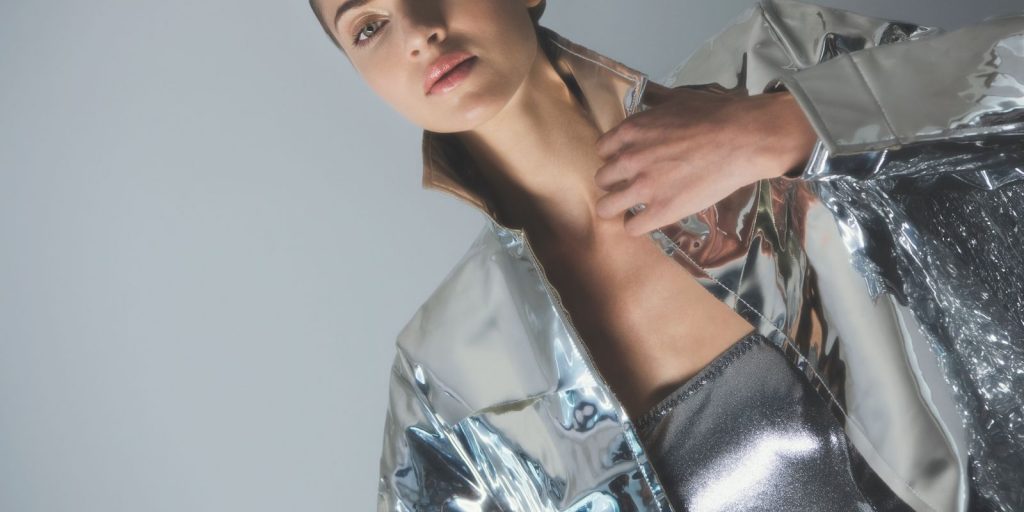 Modelo con un look plateado y futurista bajo la luz del estudio