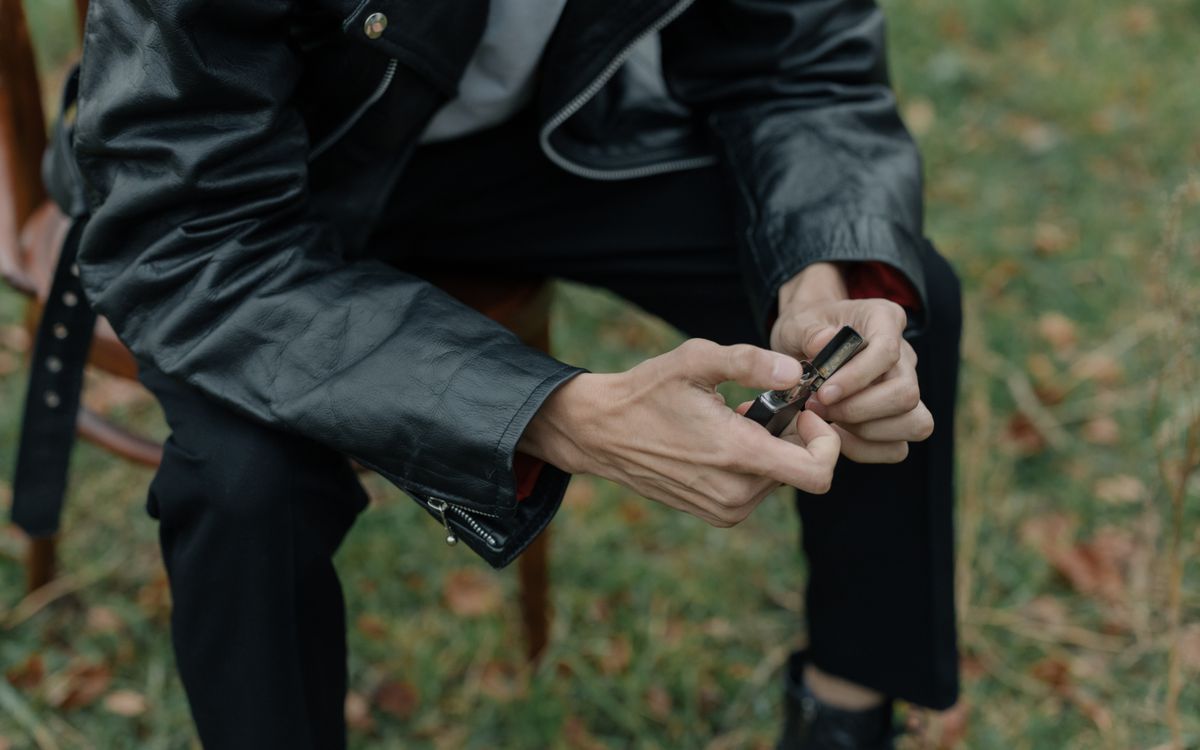 Buneri.es | Cómo Impermeabilizar una Chaqueta de Cuero: Sprays, Ceras y Frecuencia Persona con chaqueta de cuero sentada al aire libre