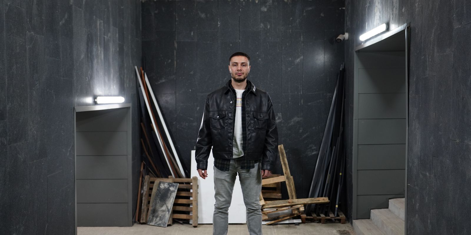Buneri.es | Cómo Reconocer una Chaqueta de Cuero de Calidad Antes de Comprar Hombre confiado con una chaqueta de cuero negra en un espacio industrial
