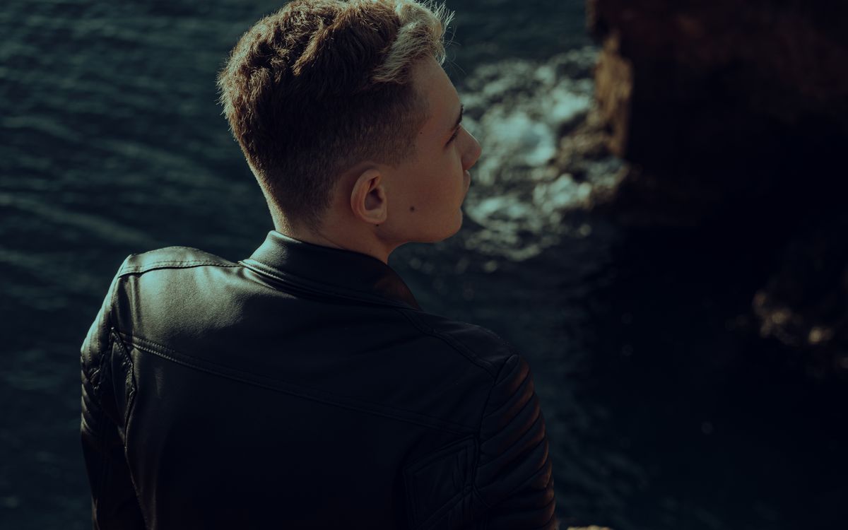 Buneri.es | ¿Se puede lavar una chaqueta de cuero en la lavadora? Joven con chaqueta de cuero mirando al mar a lo lejos