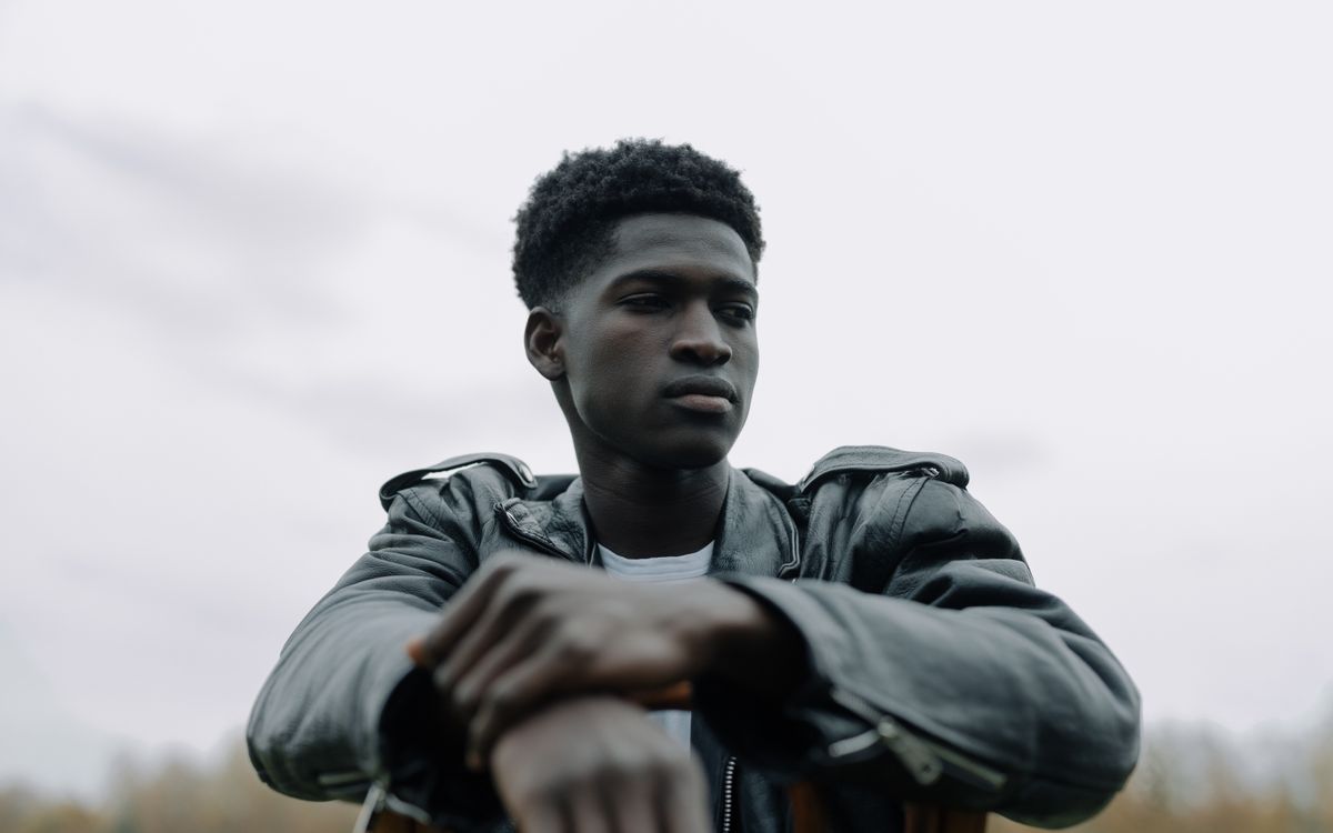 Buneri.es | Por qué los directores tecnológicos y las estrellas del rock viven en chaqueta de cuero Retrato al aire libre de un joven pensativo con chaqueta de cuero negra, transmitiendo confianza y estilo